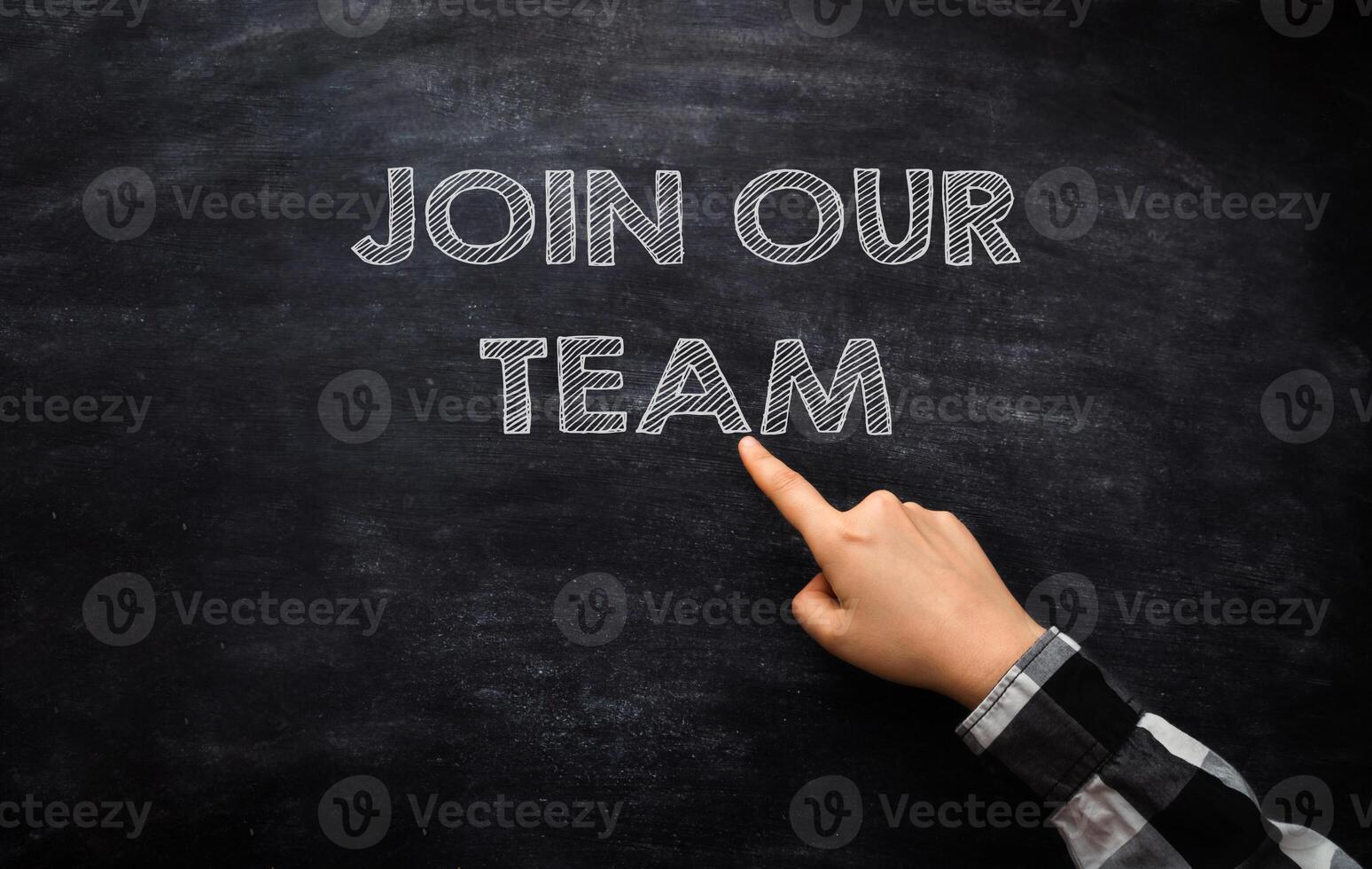 A hand points to the phrase join our team on a blackboard photo