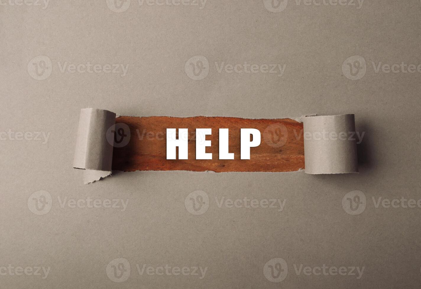 Torn piece of paper with the word HELP written on it photo