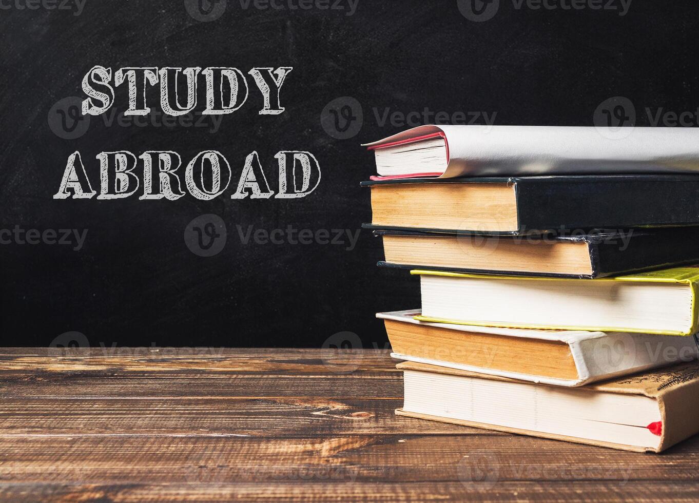 A stack of books with the word study abroad written on top photo