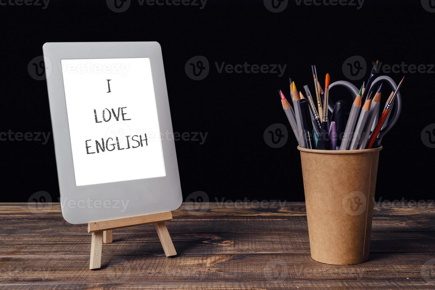 The table is also topped with a wooden stand and a cup of pencils photo