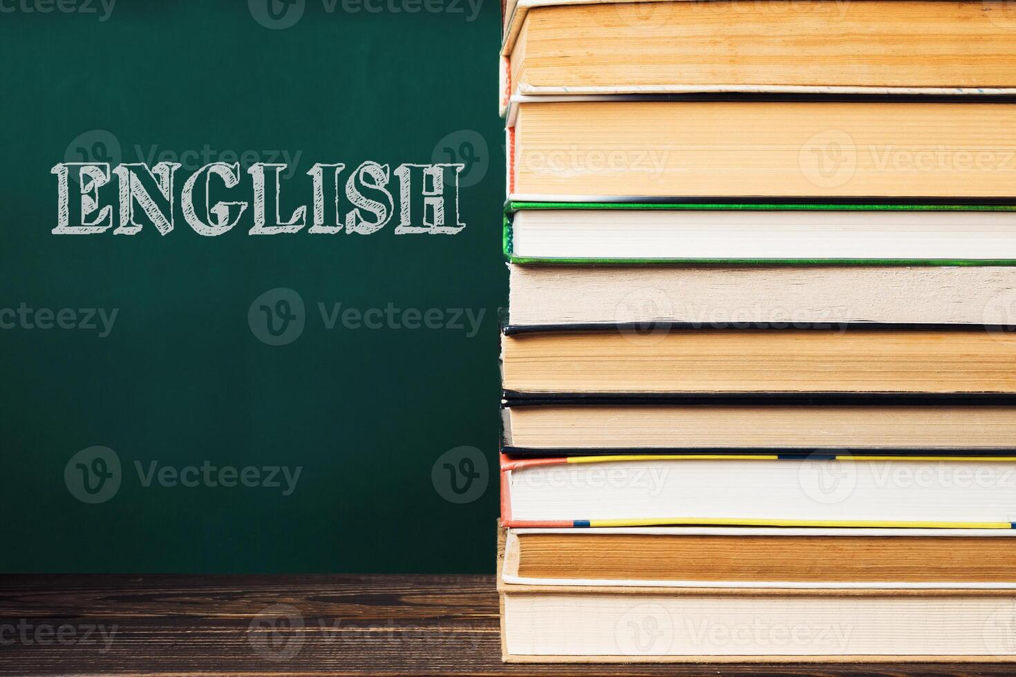 A stack of books with the word English written on the chalkboard behind them photo