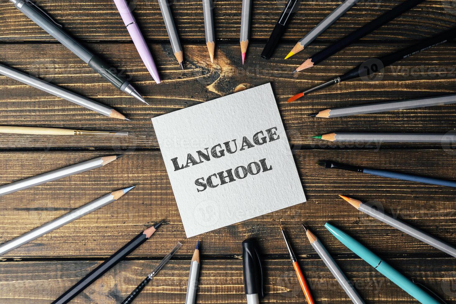 A sign with pencils and pens around it that says Language School photo