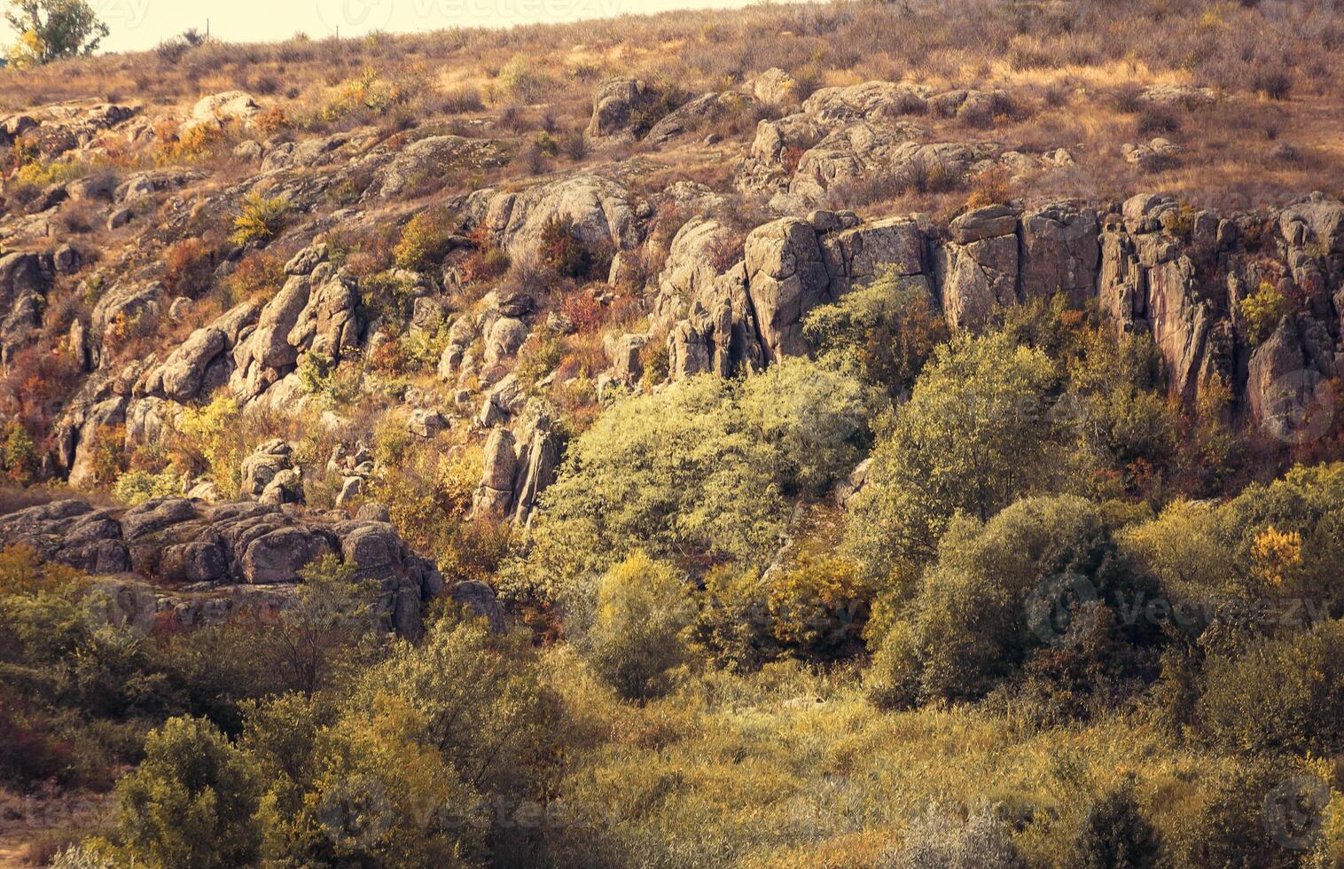 fantastic autumn in a mountain canyon, huge rocks. Mountains of large granite boulders, cliffs for mountaineering, walking, stone figures. trees grow among the rocks. Aktovsky Canyon, Ukraine. photo