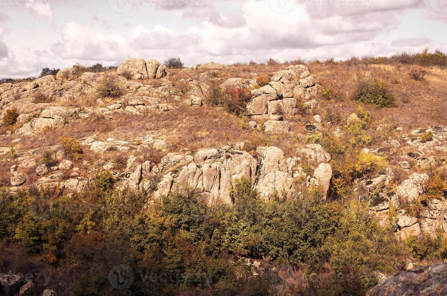 fantastic autumn in a mountain canyon, huge rocks. Mountains of large granite boulders, stone ledges for mountaineering and walking. trees and meadows grow among the rocks. Aktovsky Canyon, Ukraine. photo