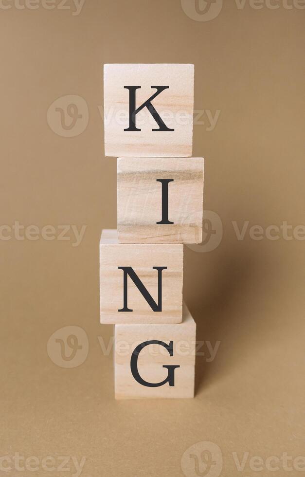 Stack of wooden blocks with the word King written on them photo