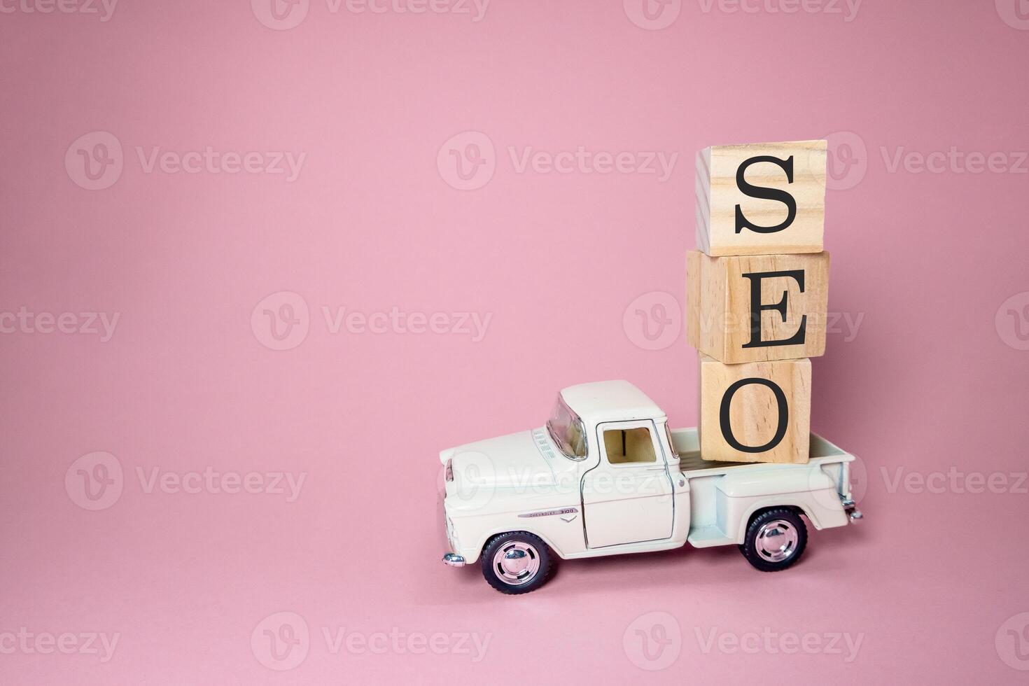 White truck is carrying blocks of wood with the letters SEO on top photo