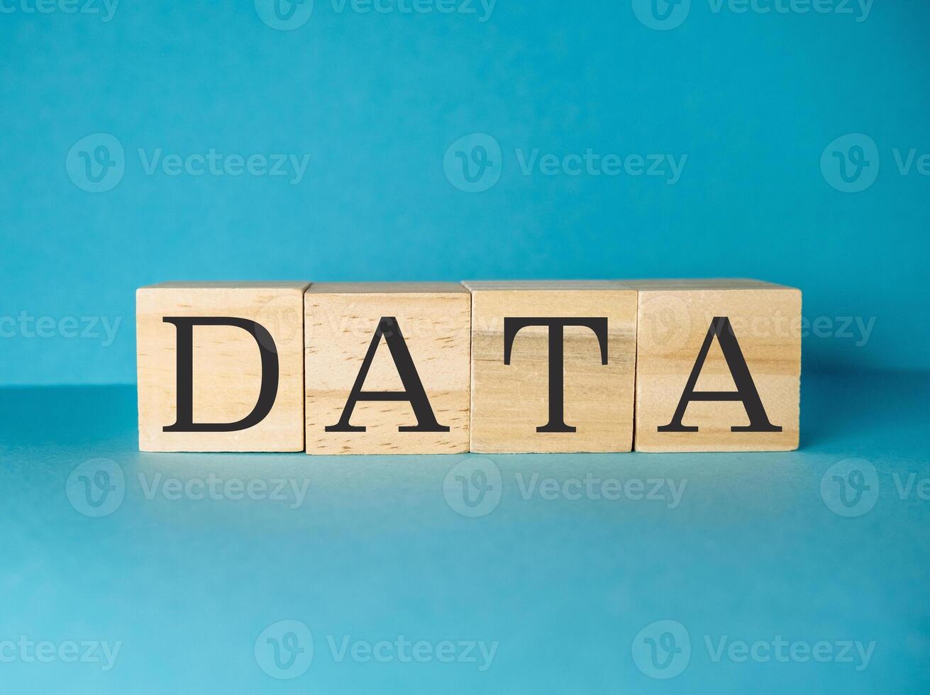 Wooden block with the letters DATA is on a blue background photo