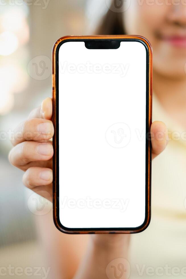 A person holds a smartphone with a blank screen, perfect for mockups or design presentations in a bright indoor environment. photo