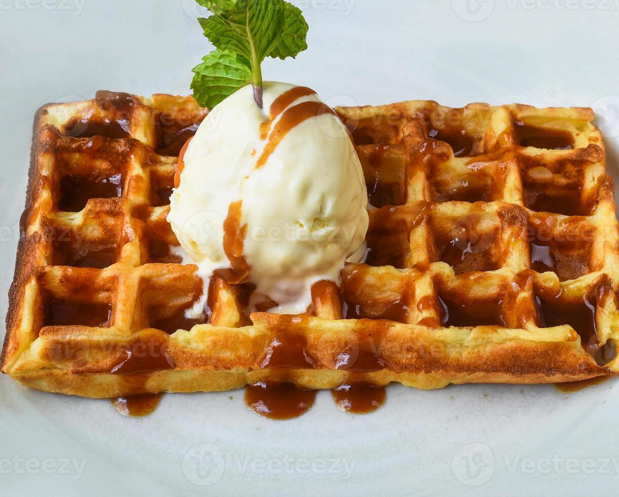 Waffle with icecream salted caramel on white plate close up photo
