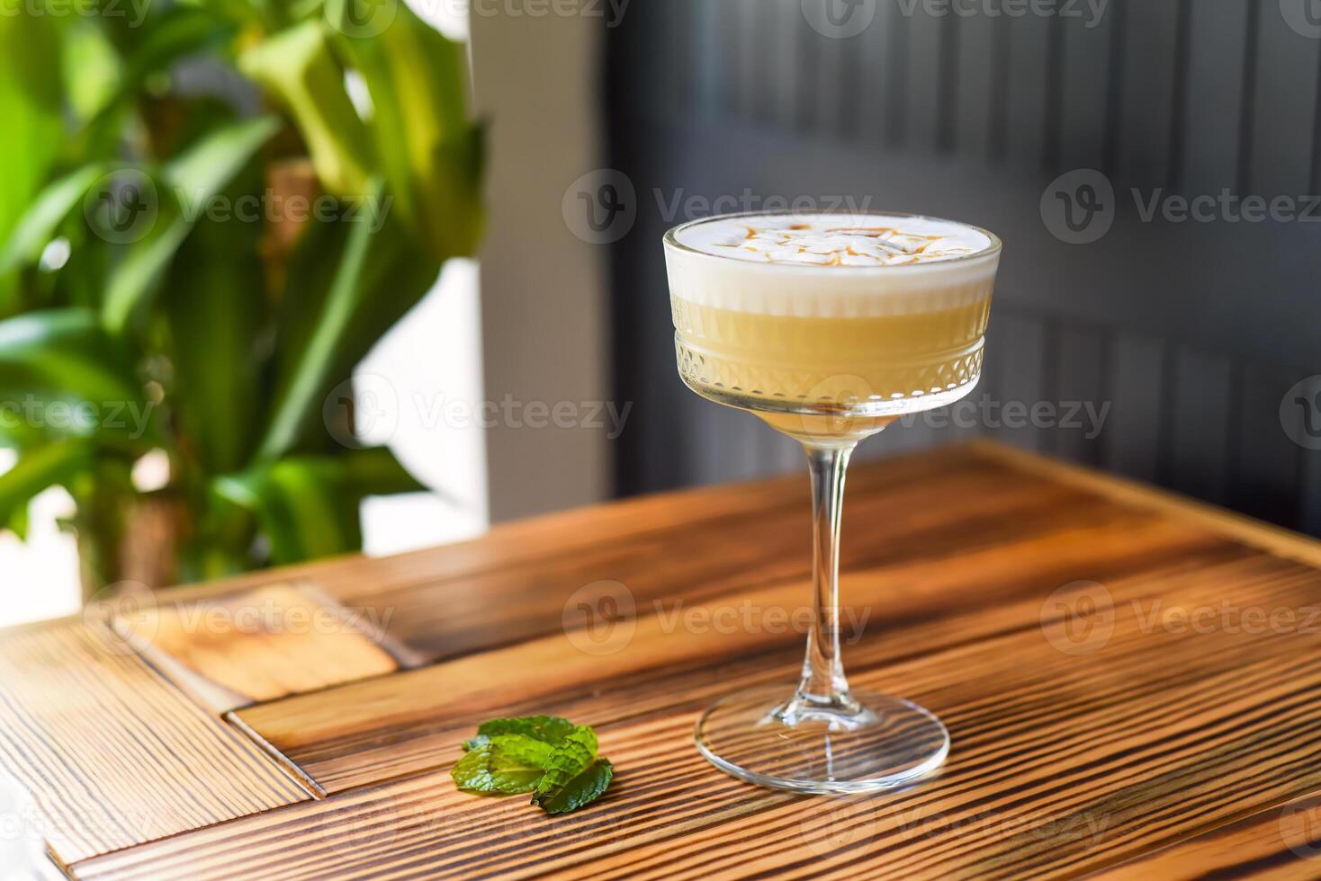 Alcohol cocktail Whisky sour on the wooden table against dark wall with copy space photo