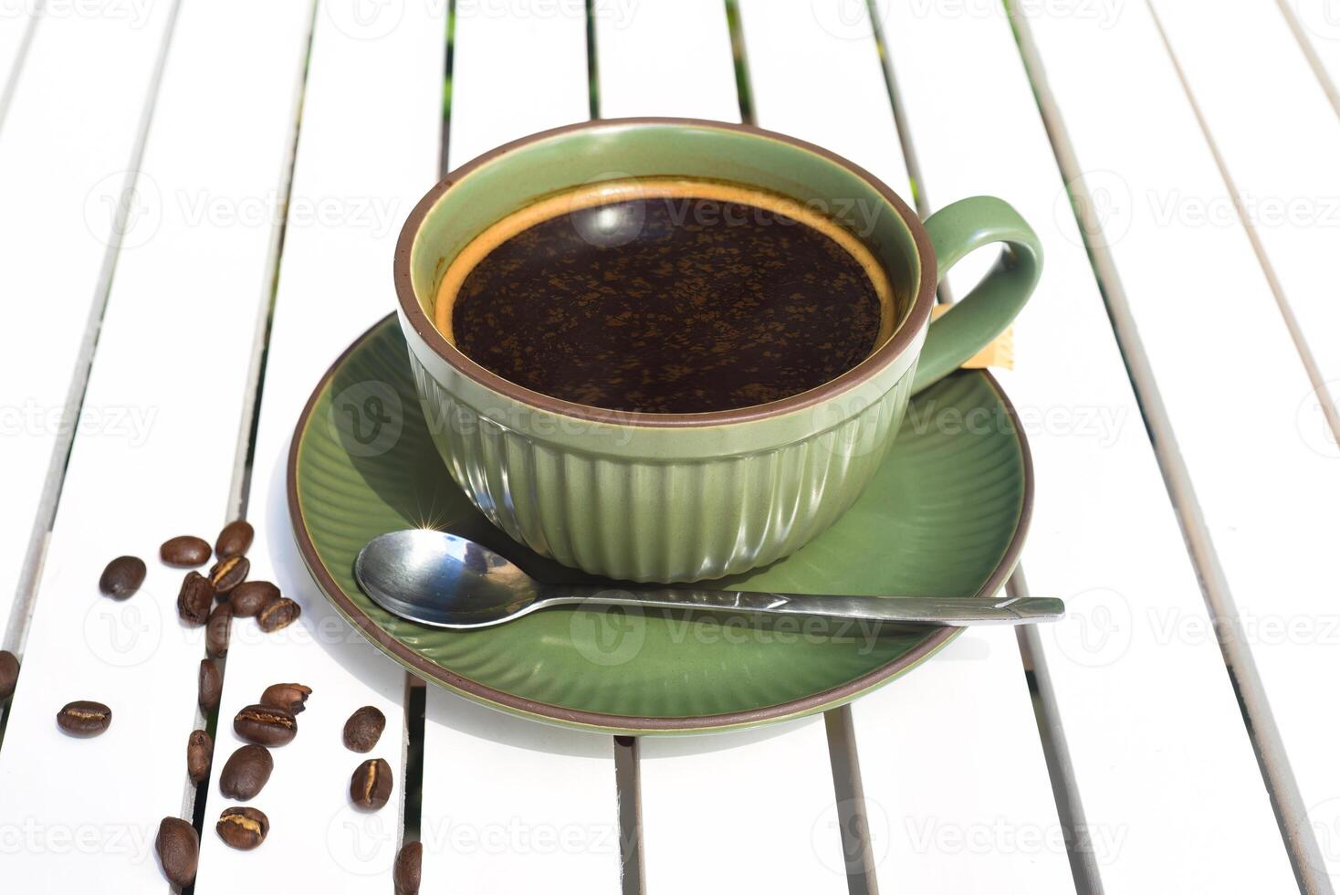 Cup of Americano with spoon and sugar on a wooden white table side view photo