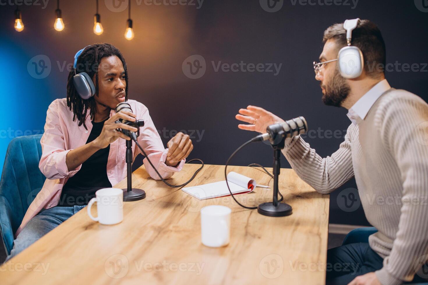 Two young men engaging in conversation while recording a podcast in a professional studio, surrounded by microphones and audio equipment photo