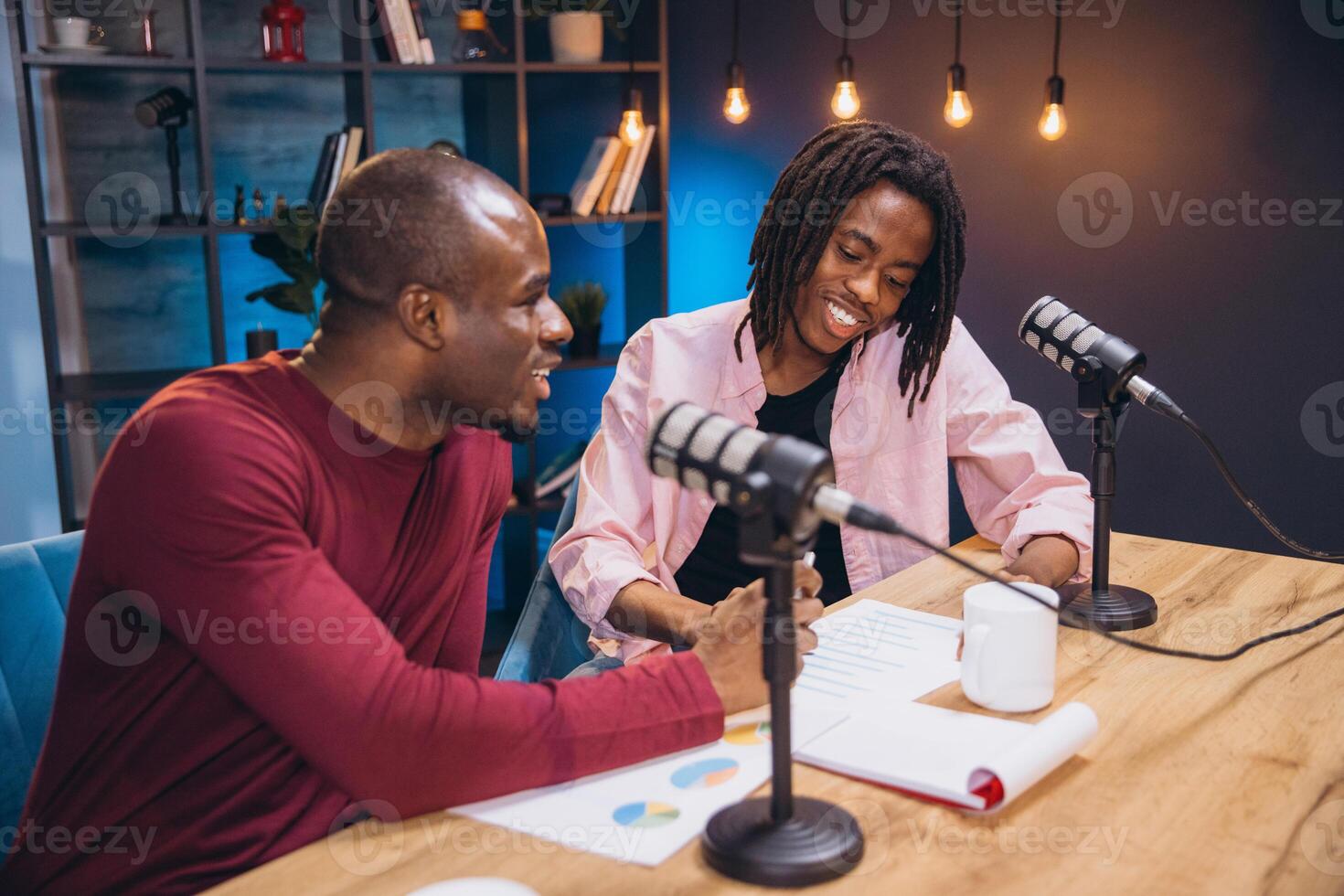 Two podcasters engaging in a lively discussion while recording a new episode in a modern, professional studio setting photo