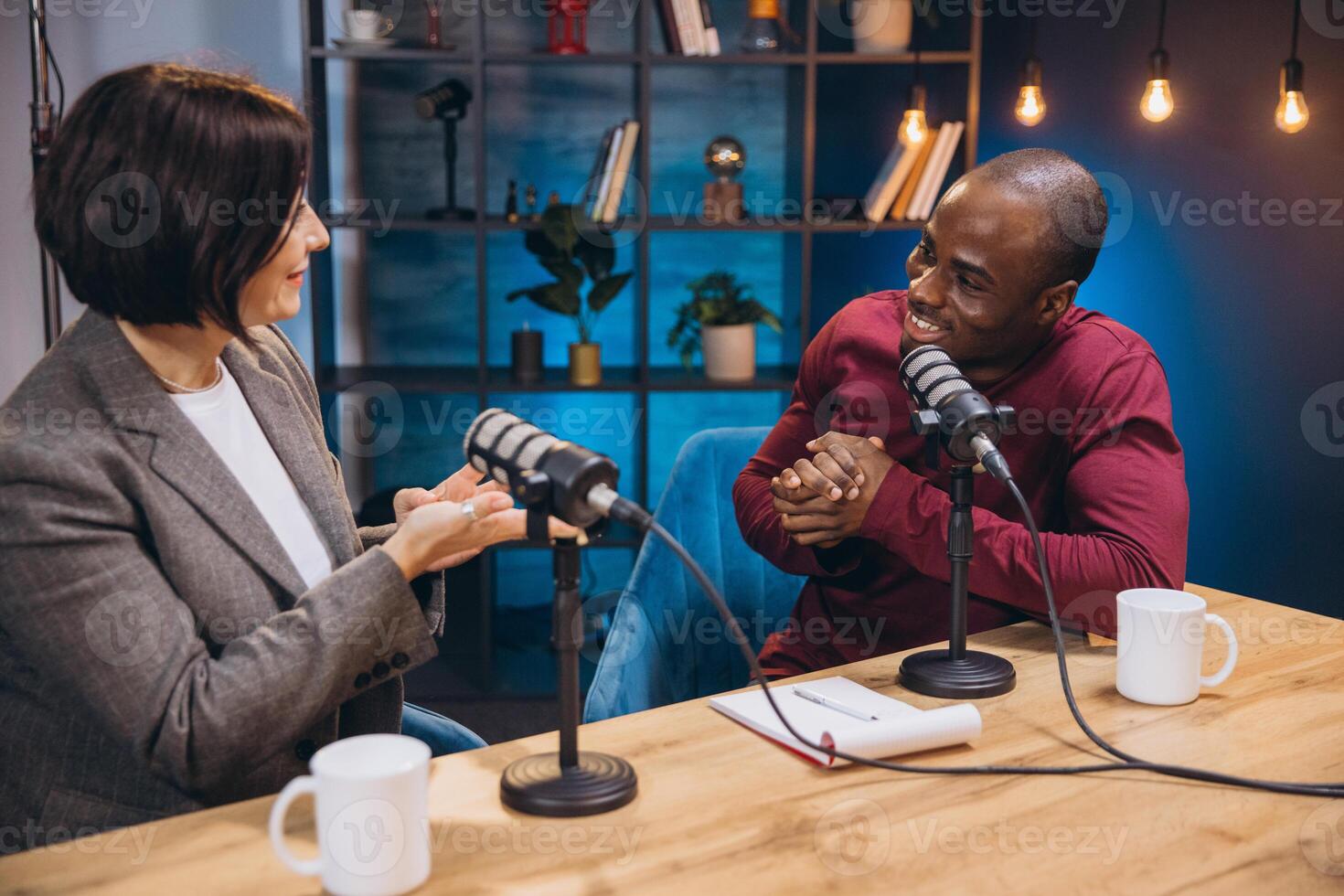 Podcasters engaging in lively conversation while recording an episode in a modern studio, surrounded by professional equipment and a vibrant atmosphere photo