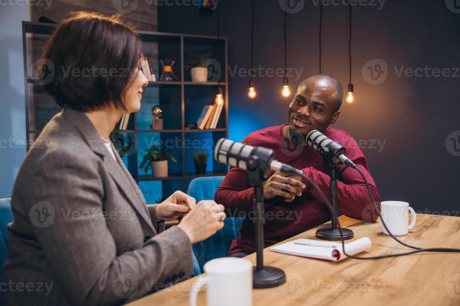 Podcasters engaging in lively conversation during a dynamic live recording session in a modern studio environment photo