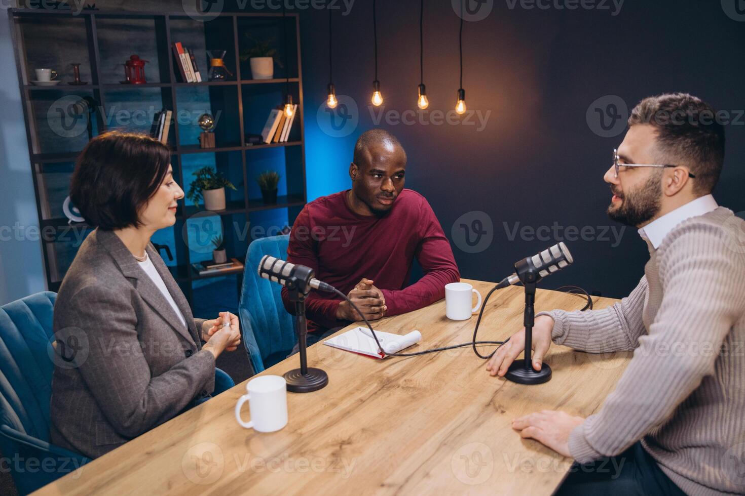 Podcasters engaging in lively discussions during a recording session in a studio filled with microphones and advanced audio equipment photo