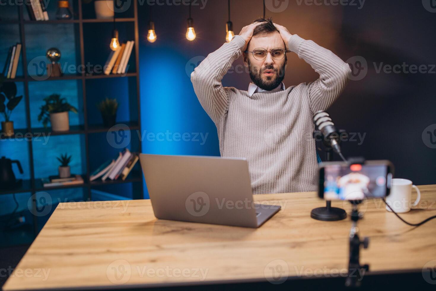 Frustrated podcast host struggling with technical issues during live streaming, hands covering face in stress photo