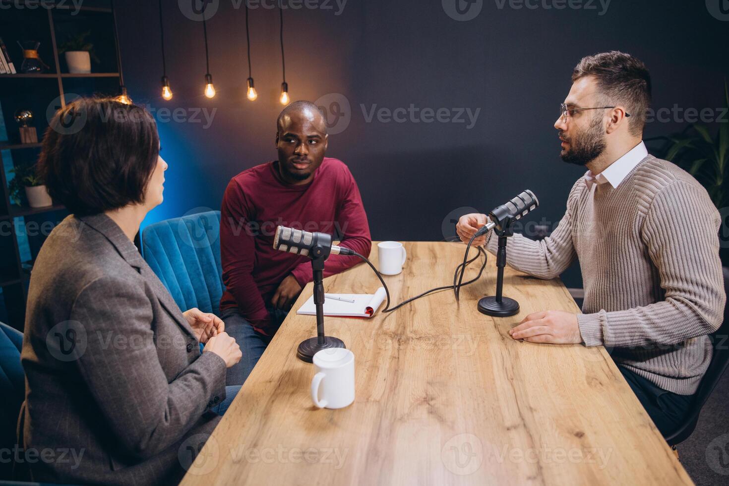 Content creators recording an interview in a studio, using professional microphones and equipment photo