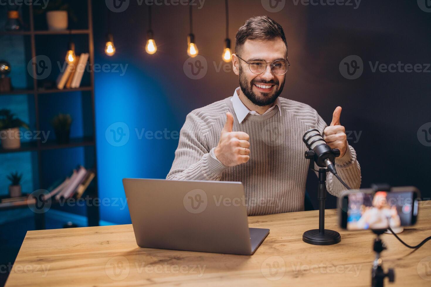 Happy podcaster giving a thumbs up while recording engaging content in a home studio, surrounded by modern technology and creativity photo