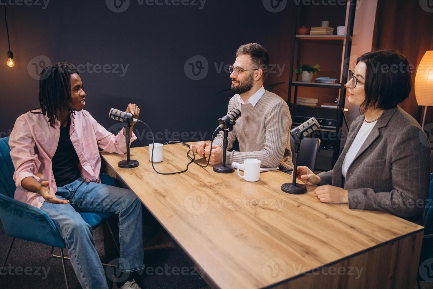 Professional radio team interviewing guest, utilizing modern studio microphones and broadcasting technology photo