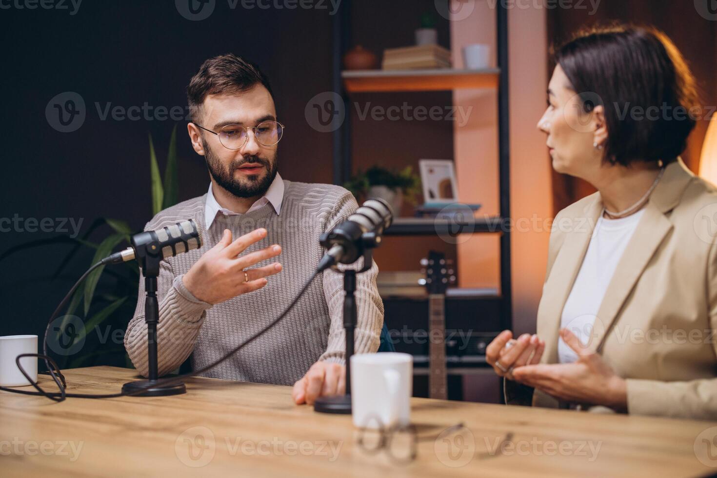 Professional podcasters recording audio using studio microphones within dynamic radio station workspace photo