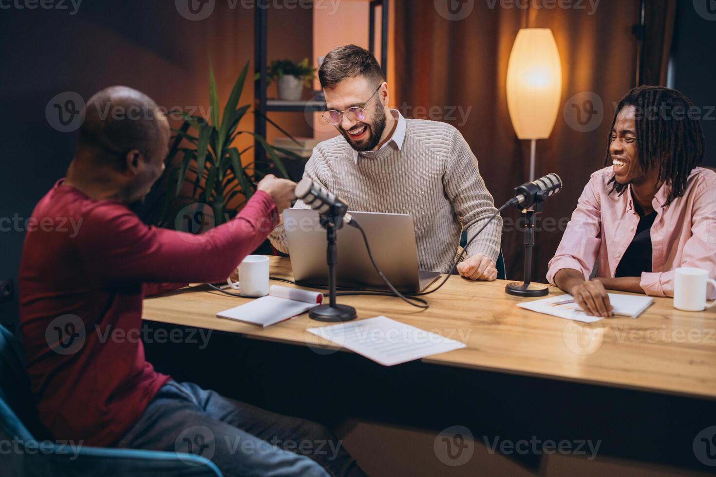 Podcasters bumping fists, celebrating podcast success during live recording, sharing energetic moment in professional studio environment photo