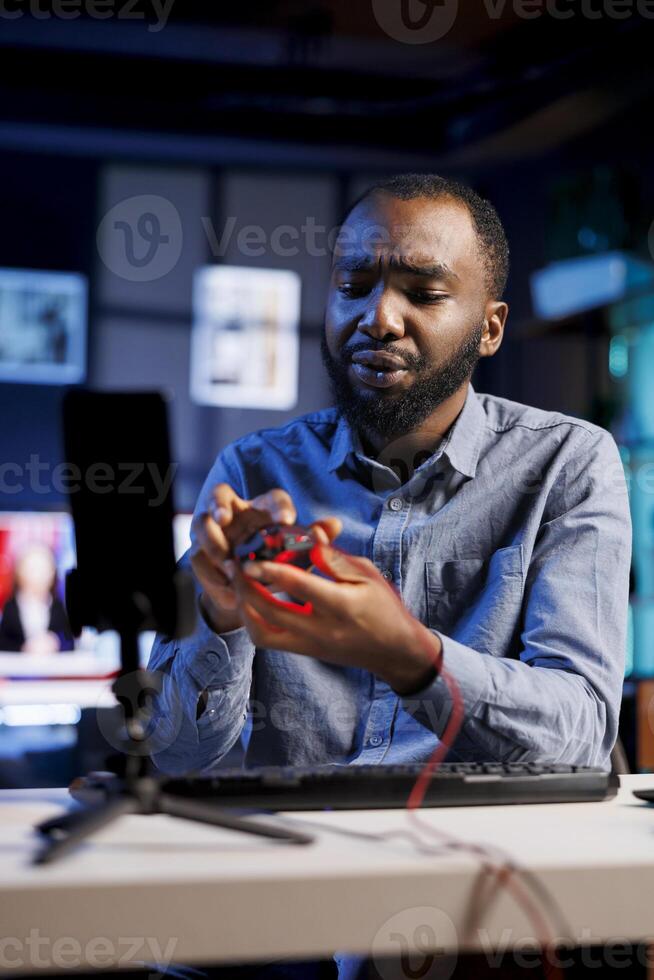 Tech guru filming review of newly released gaming led lights mouse, disappointed by subpar quality. Content creator giving audience low rating feedback about computer peripheral performance photo