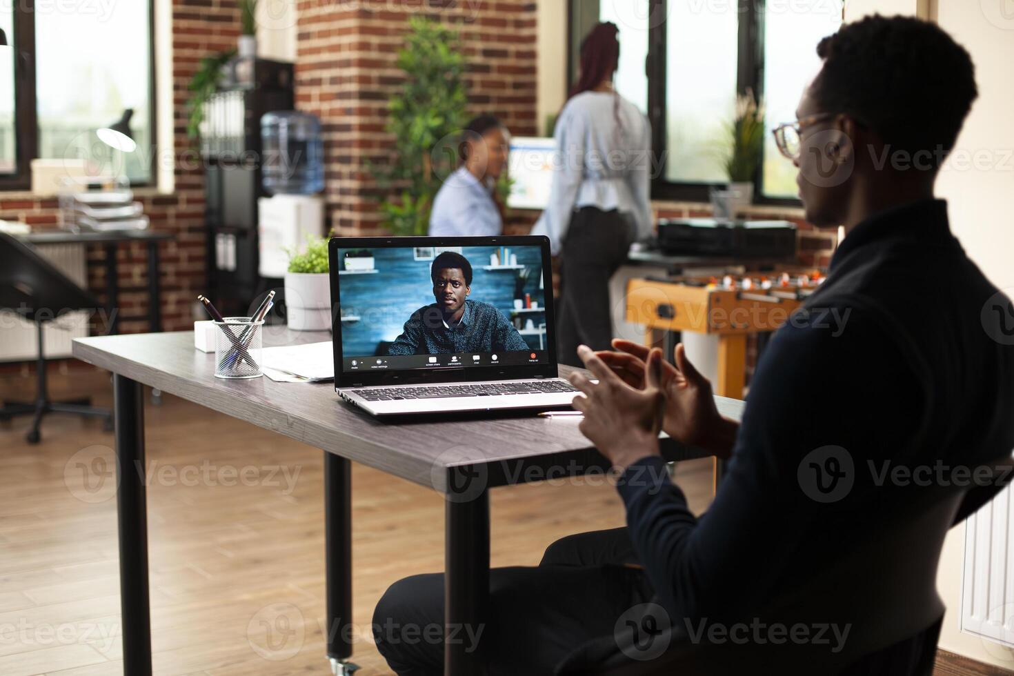 Male entrepreneur leading a videoconference with a client, focusing on executing marketing strategies. Black businessmen on an online meeting, reviewing development plans and project strategies. photo