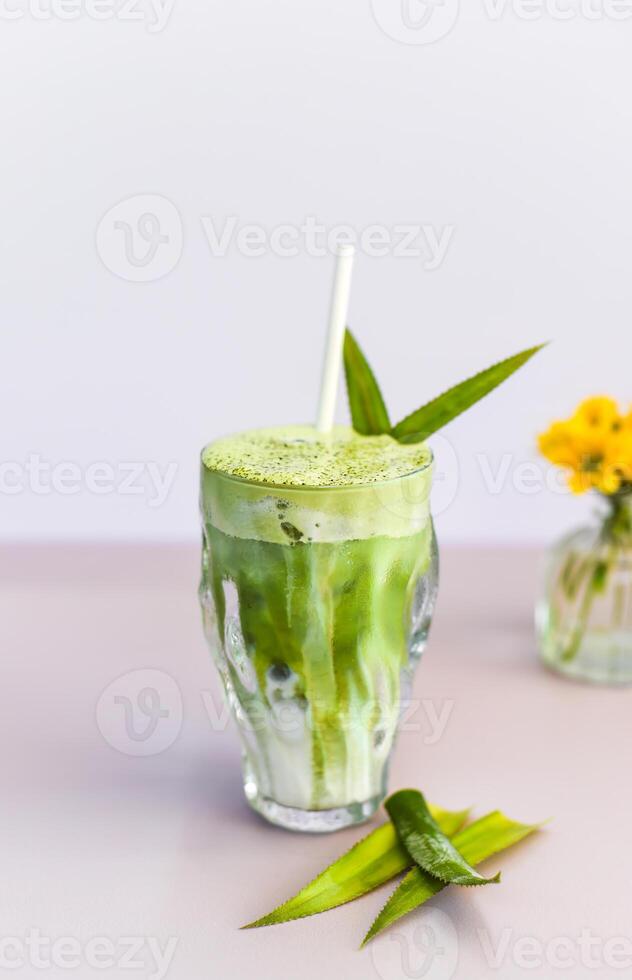 blended brew matcha latte with the straw on light gray background photo
