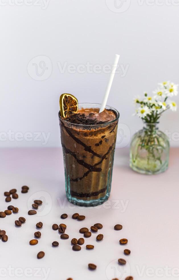 Cacao drink with banana and peanut butter on a table with vase of flowers photo