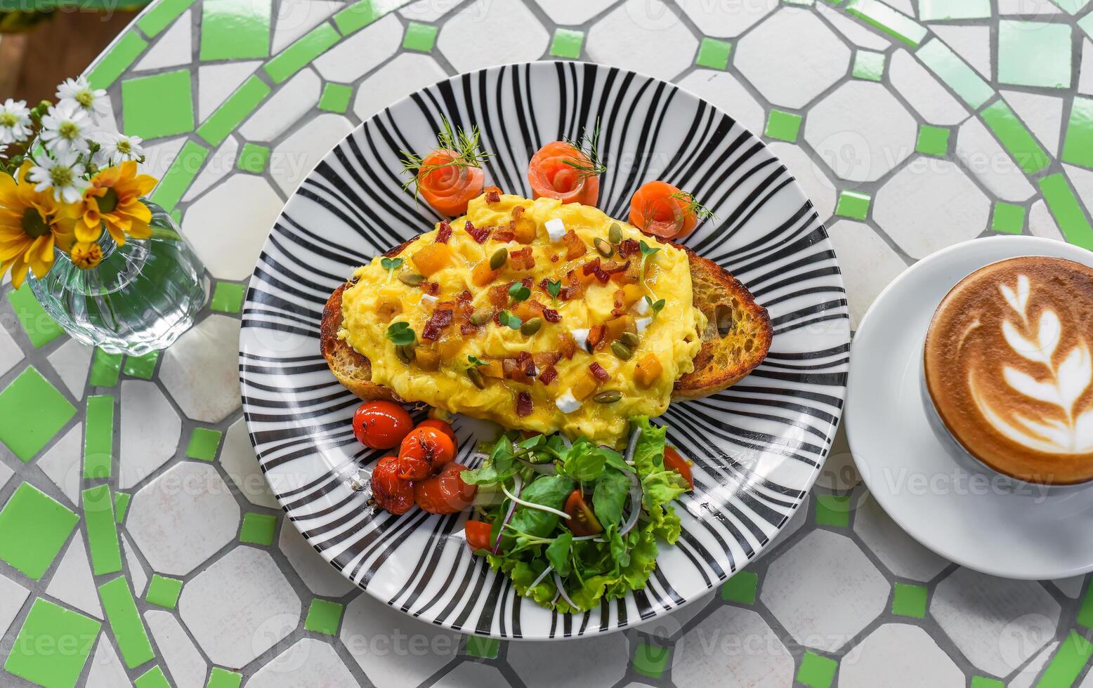 Toast with scrambled eggs pumpkin puree and cubes, smoked salmon and pumpkin seeds photo
