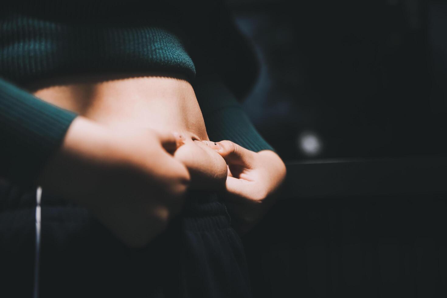 A woman is holding her stomach in her hands photo