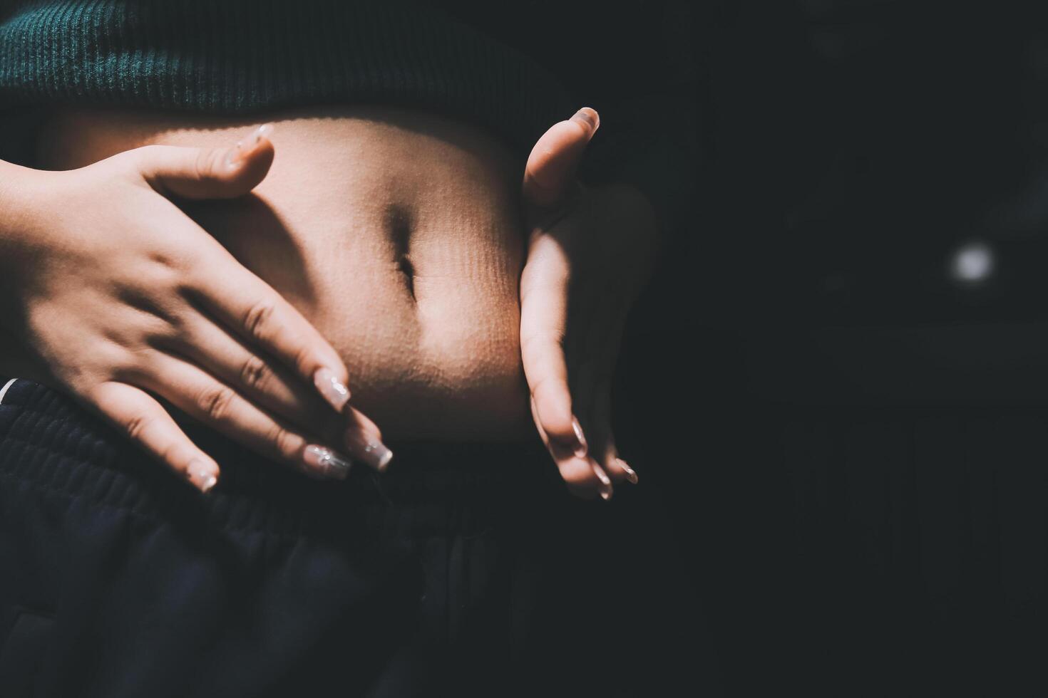 A woman is holding her stomach with her hands photo