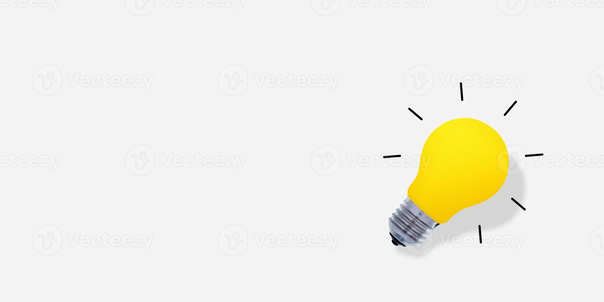 Yellow glass bulb with hard shadow, on the left side. Lightbulb on white background photo