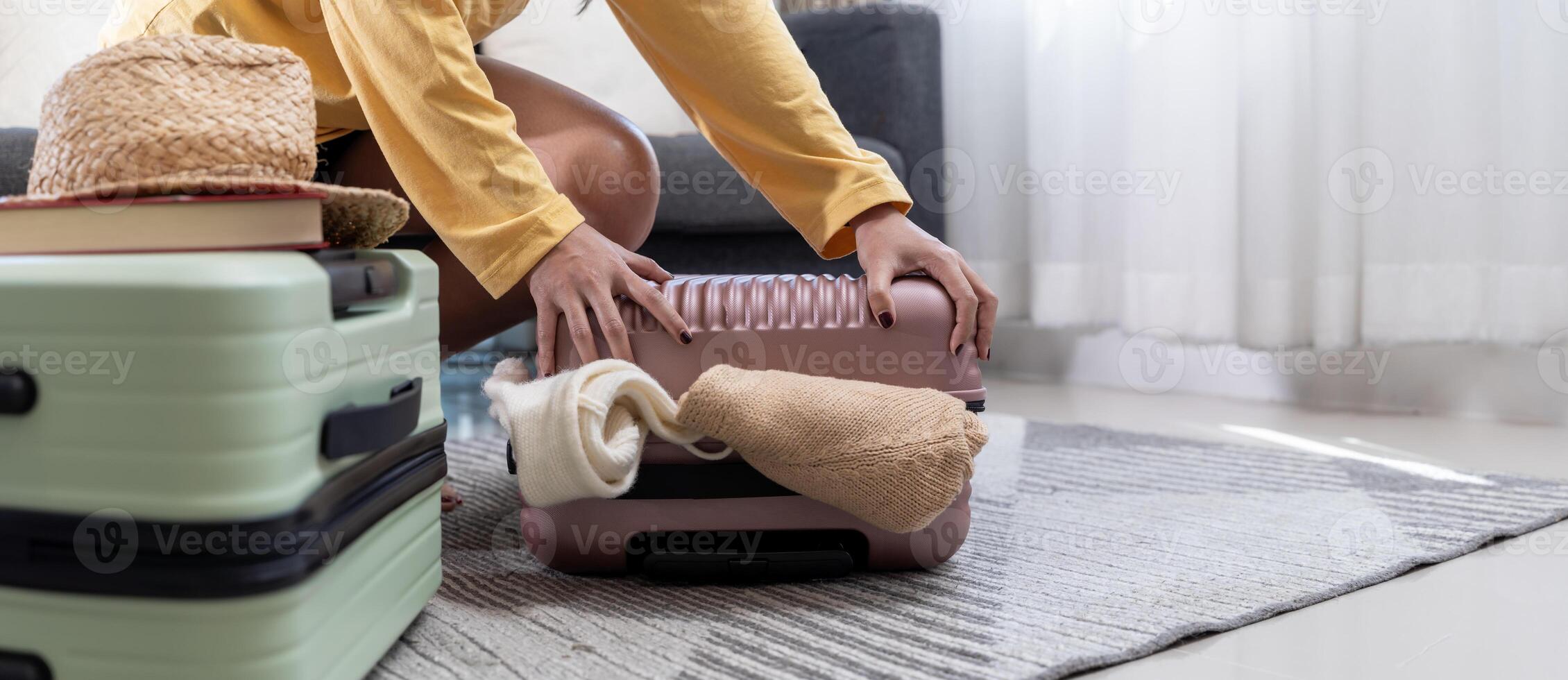 Always prepared. Woman sorting through clothes in bag. Packing for vacation. Smiling woman sitting on floor with suitcase. photo