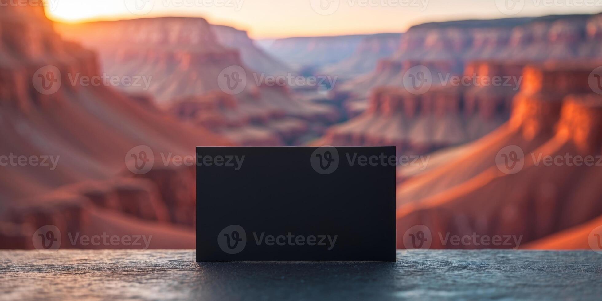 Black business card showing a colorful canyon illuminated by setting sun. photo
