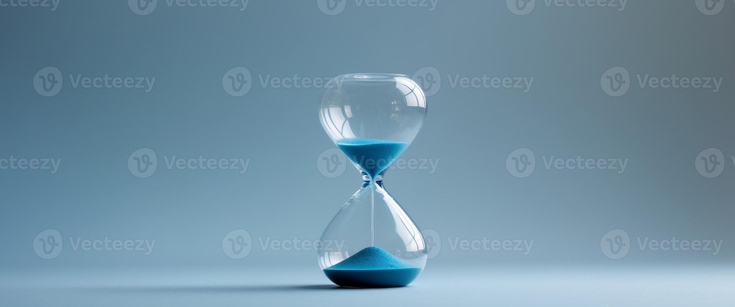 Hourglass on a blue background symbolizing the passage of time photo