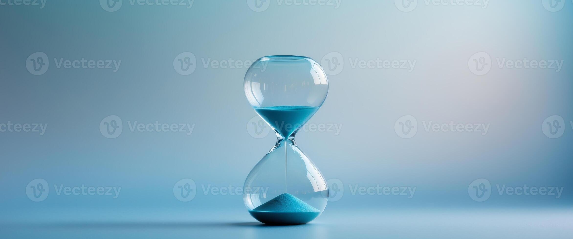 Hourglass on a blue background symbolizing the passage of time. photo