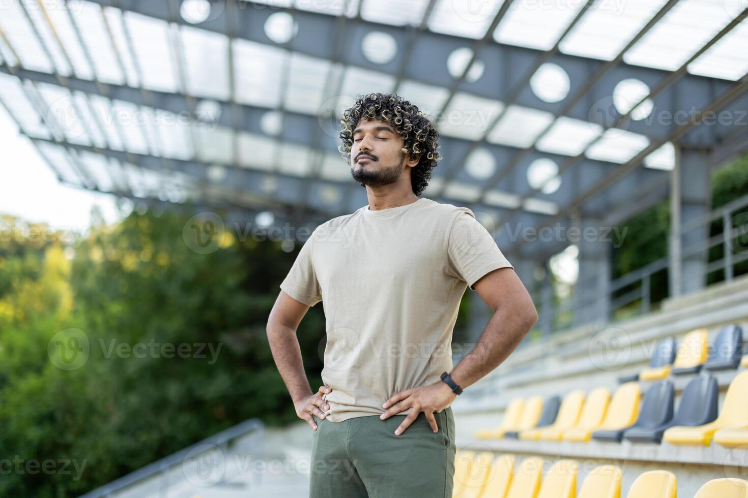 Athlete resting at the stadium, man breathing with eyes closed after active physical exercise and fitness. photo