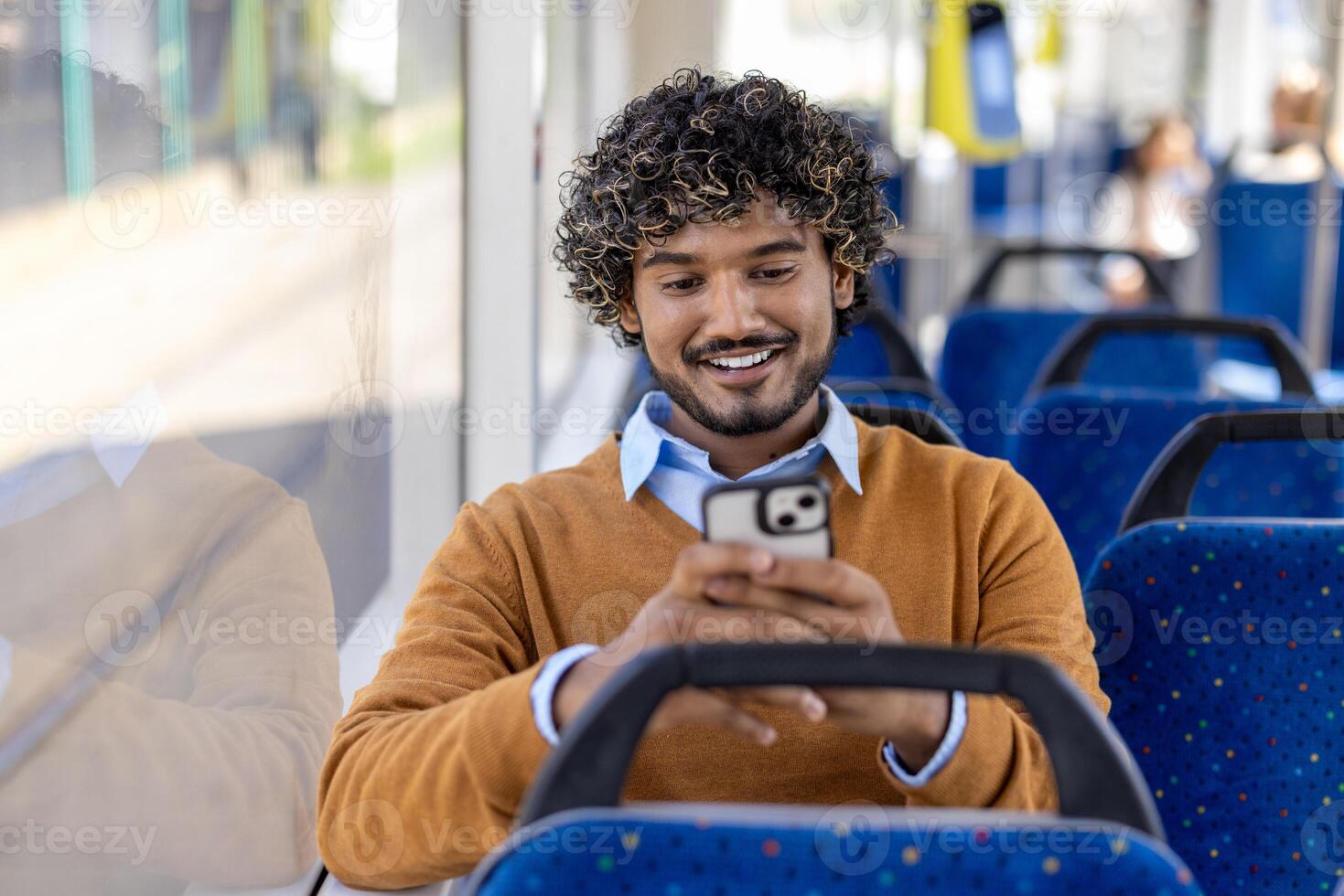 Public transport passenger uses phone while sitting. Man smiles contentedly typing message on smartphone and browsing social media. photo