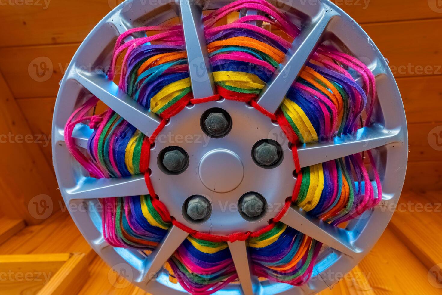 Unique wheel cover featuring vibrant colored strands in a decorative pattern at a craft market photo