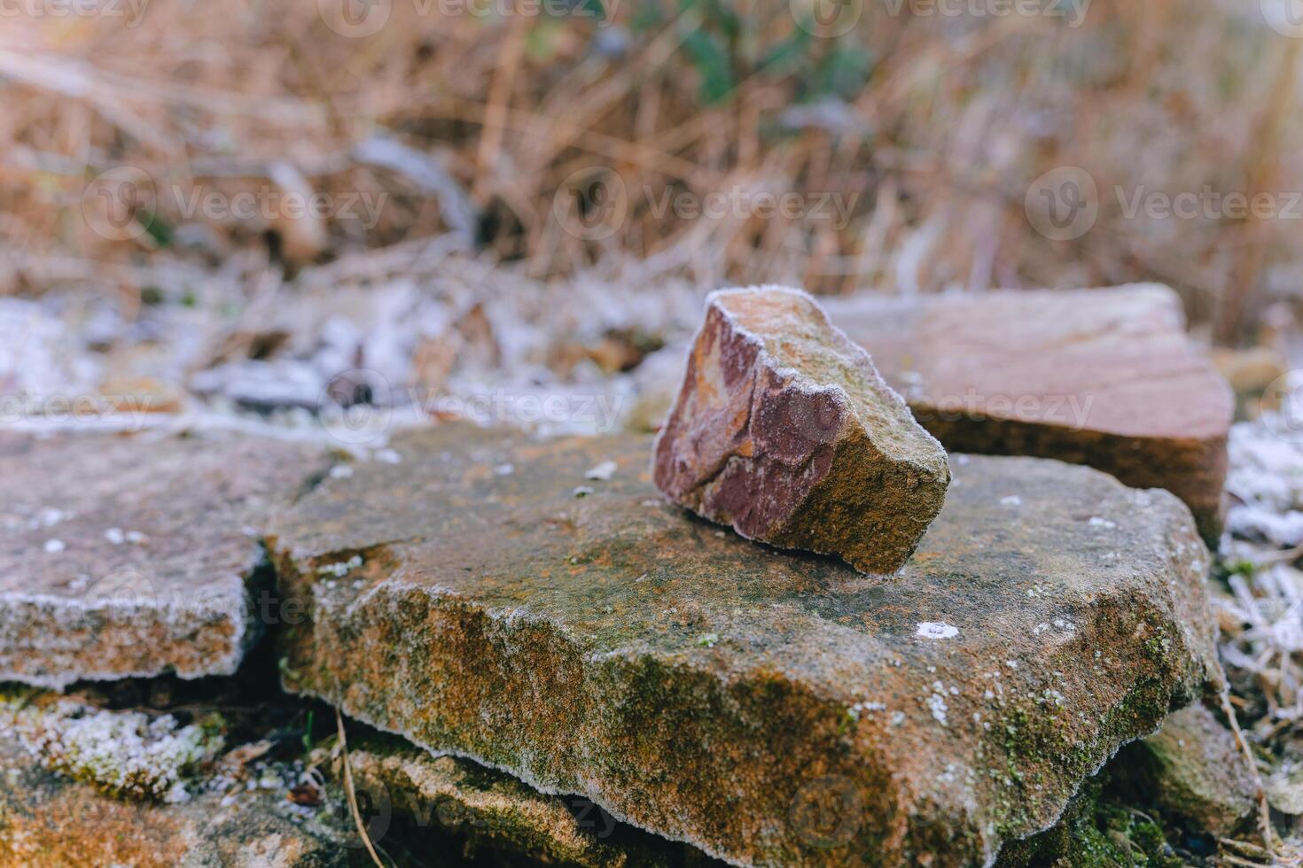 Rocks resting on textured surface in a natural setting during early morning light photo