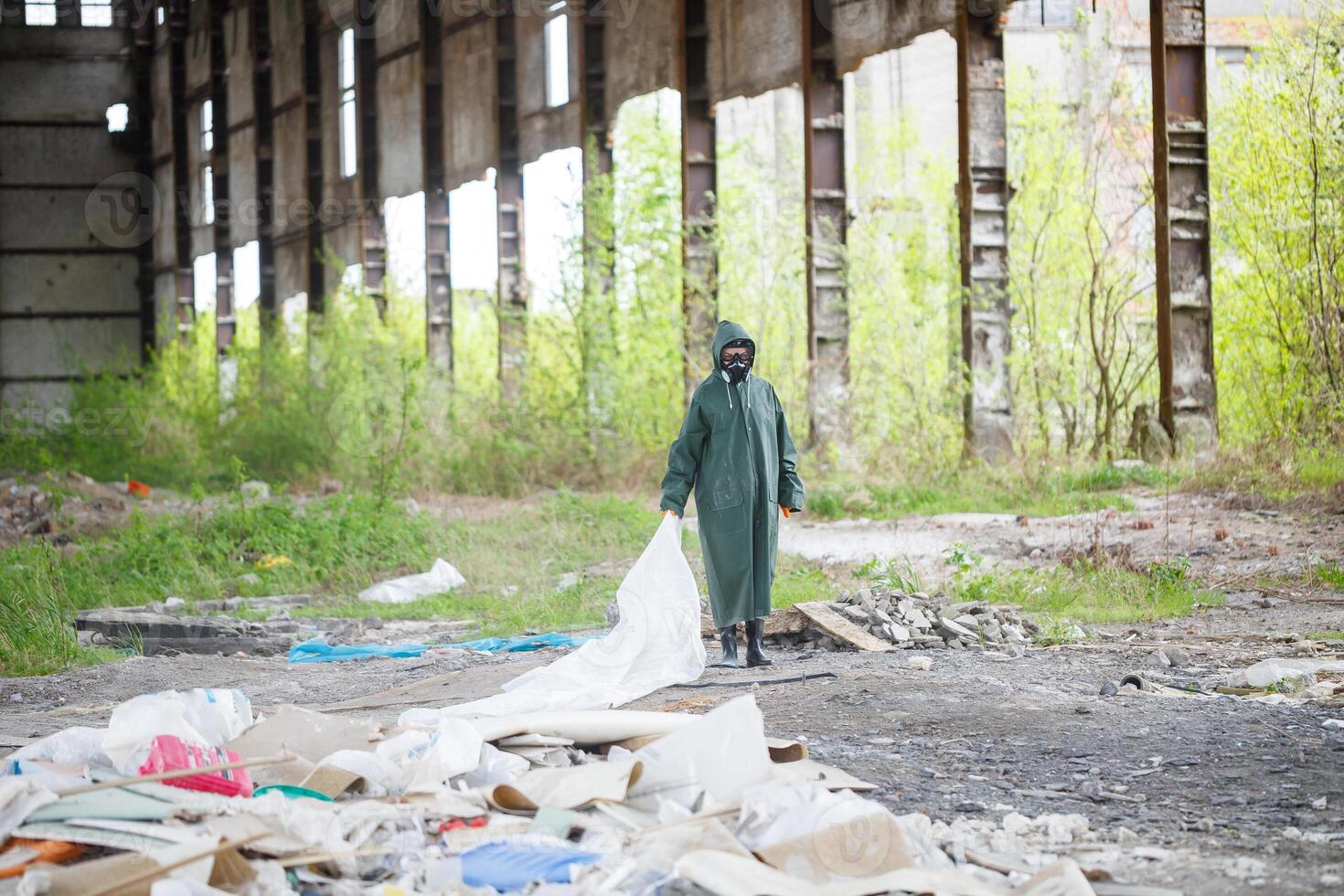A man in a protective mask and protective clothing explores the danger zone. Ecological catastrophe photo
