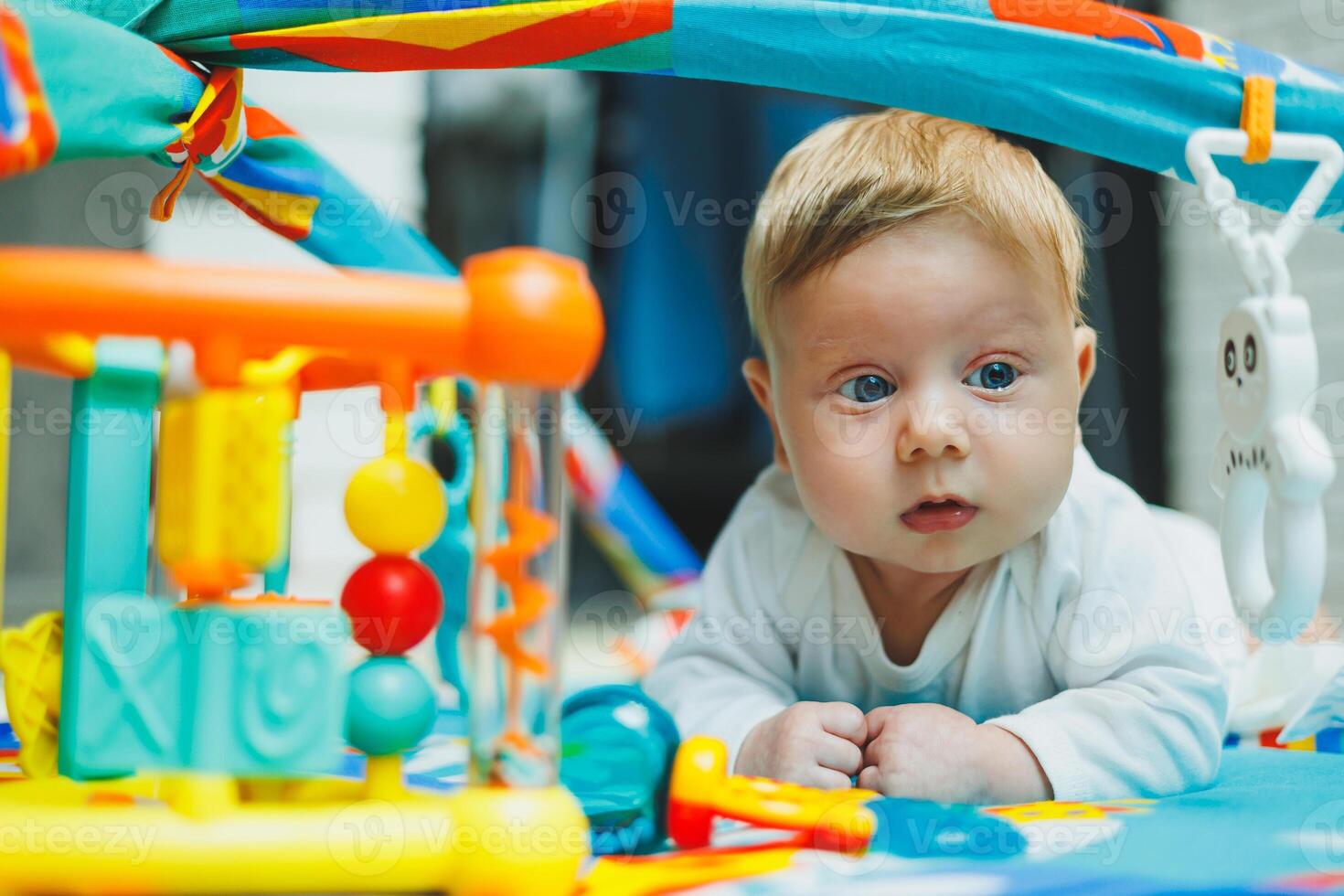 baby plays on a developmental mat for two months. Toy rug for small children. photo