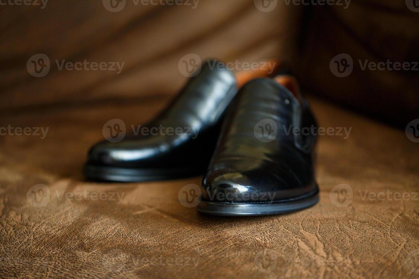 black leather shoes on a brown photo