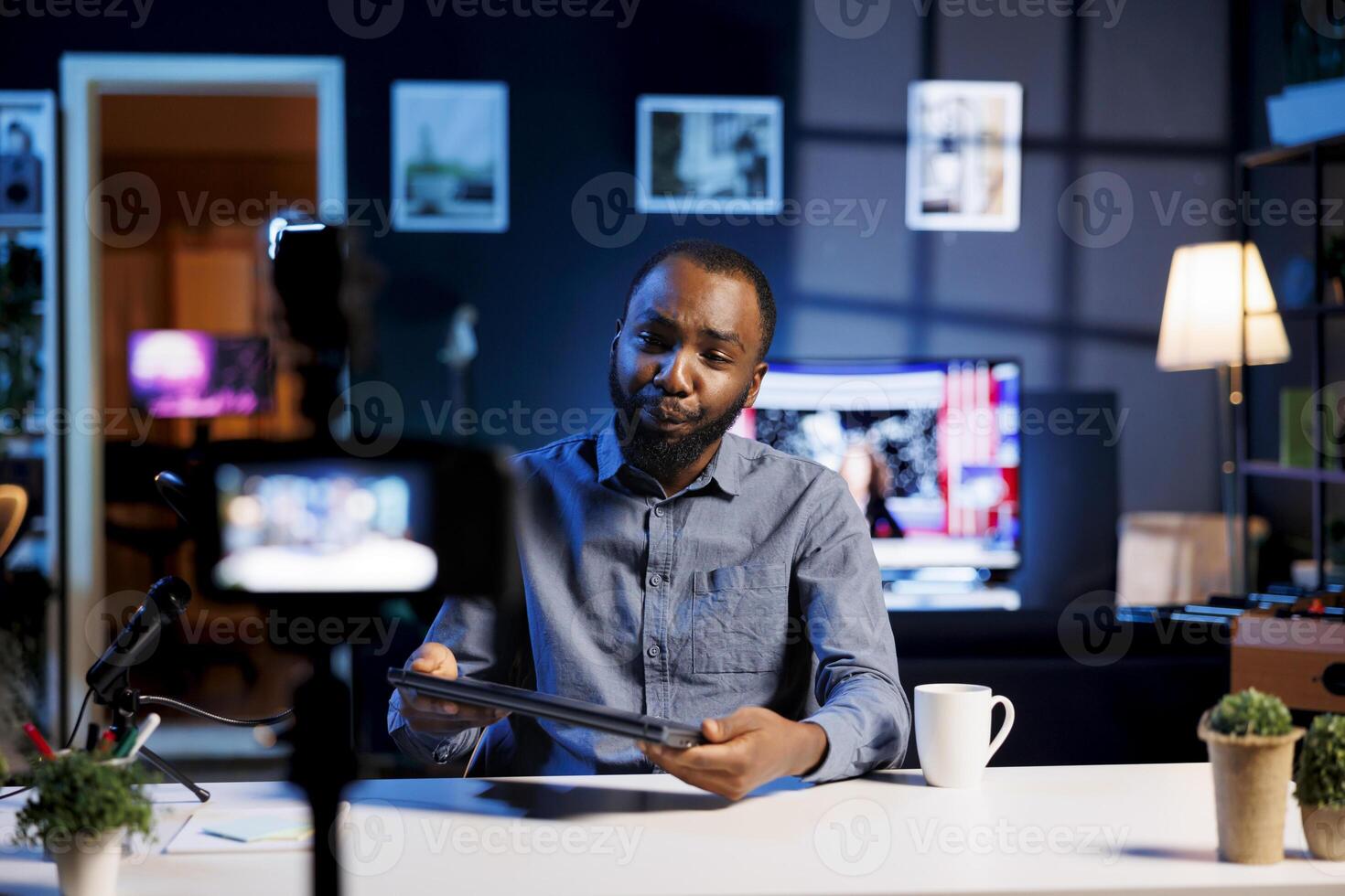 African american influencer filming tech tutorial on how to do maintenance on laptop, presenting internal parts. Technology internet show host teaching subscribers to fix notebook device photo