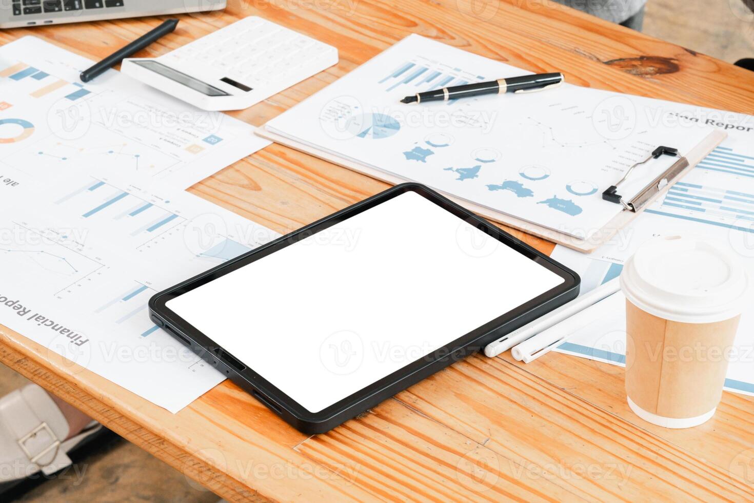 Blank tablet on a desk surrounded by business documents, coffee, and office supplies, ideal for modern work or study themes. photo