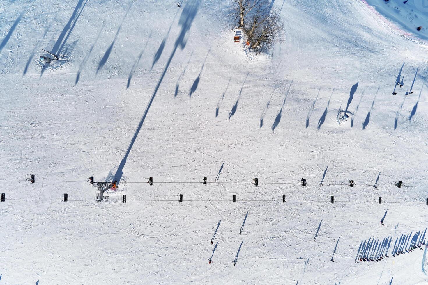 Aerial view of snowy ski slope with skiers and lifts. Winter sports photo