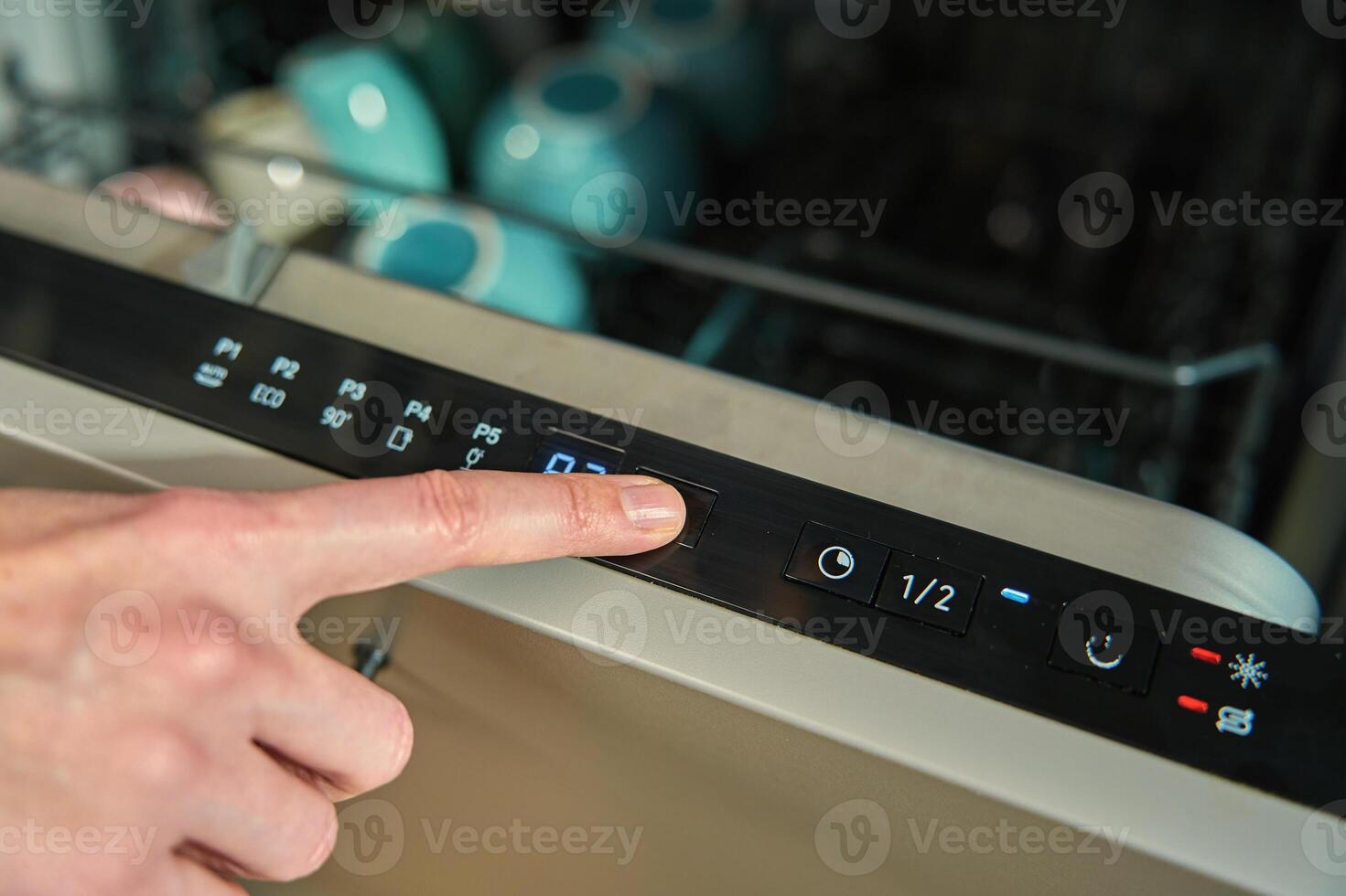 Finger pressing button on dishwasher control panel photo