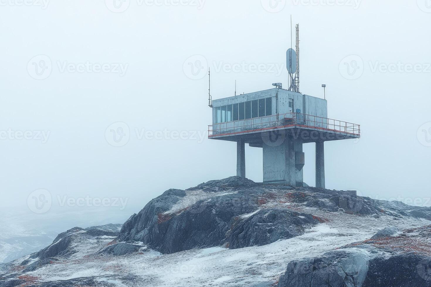 Abandoned weather station perched on snowy mountain top in misty conditions photo